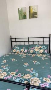 a bed with a blanket with flowers on it at 3 BDR house close to train station, airport & City in Sydney