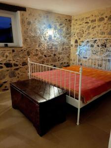 - une chambre avec un lit dans un mur en pierre dans l'établissement Casa Mare * Monte * Mille Stelle, à Santa Caterina dello Ionio