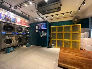 uma lavandaria com duas máquinas de lavar roupa e uma porta amarela em M Suite Homestay, Aeropod Sovo Kota Kinabalu em Tanjong Aru