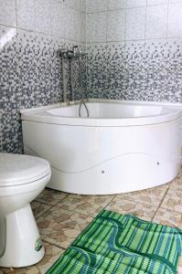 bagno con vasca bianca e servizi igienici di Guest house В гостях у Лаззат a Türkistan