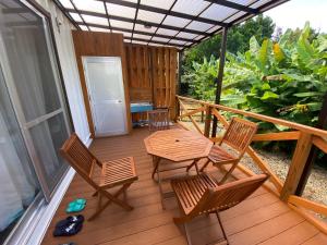 a porch with chairs and a table on a deck at Bise House in Motobu