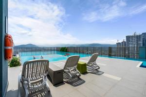 a patio with chairs and a table and a swimming pool at 3Towers @ KL City Centre in Kuala Lumpur