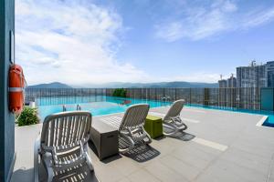 a patio with chairs and a table and a swimming pool at 3Towers @ KL City Centre in Kuala Lumpur