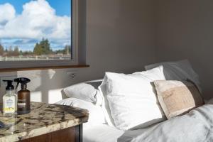 um quarto com uma cama com almofadas brancas e uma janela em Blue Moon Tiny House, Sauna,ht em Port Angeles