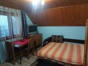- une chambre avec une table, un lit et un bureau dans l'établissement Kuca - STUDIO, à Požega