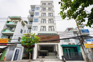 um edifício alto e branco com uma placa à frente. em Haven Hut Riverside Hotel em Ho Chi Minh