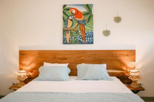 a bedroom with a large bed with a parrot painting on the wall at Villa Makai 2 Blue in El Paredón Buena Vista