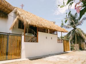 una casa con techo de paja y puerta en Villa Makai 2 Blue en El Paredón Buena Vista