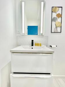 Baño blanco con lavabo y espejo en Niort - chez Coco - Duplex, en Niort