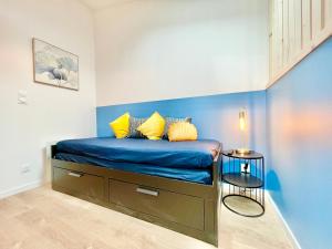 1 dormitorio con 1 cama con pared azul en Niort - chez Coco - Duplex, en Niort
