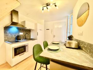 una cocina con encimera con sillas verdes. en Niort - chez Coco - Duplex, en Niort