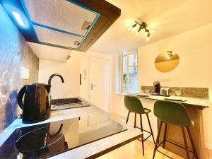 una cocina con 2 sillas verdes y una barra en Niort - chez Coco - Duplex, en Niort