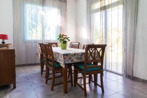 una mesa de comedor con sillas y un jarrón de flores. en villa Anthalo, en La Saline-Les-Bains