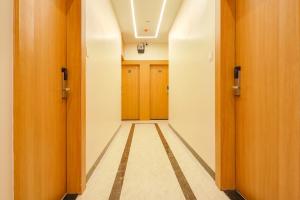 an empty hallway with wooden doors and a hallwayngth at FabHotel The Gravity Inn in Indore