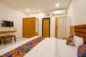 a bedroom with a bed and a tv in it at FabHotel The Gravity Inn in Indore