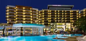 a hotel with a swimming pool at night at Flamingo Grand Hotel & Spa in Albena