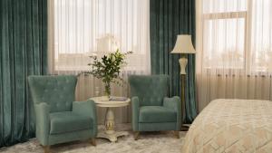 - une chambre avec deux chaises, une table et un lit dans l'établissement DiliMah Premium Luxury, à Samarcande