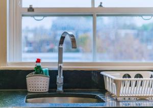 a kitchen sink with a faucet next to a window at Kensington & Chelsea - Stylish Apartment in Central London in London