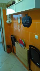 a kitchen with two black chairs and an orange wall at Apartamento en Tetuán in Tetouan