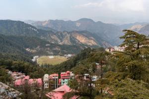 une ville dans une vallée avec des montagnes en arrière-plan dans l'établissement Treebo Trend Varuna With Mountain View, à Shimla