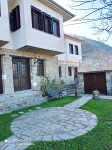 una casa con un banco delante de un patio en ΟΡΕΙΝΟ ΟΝΕΙΡΟ, en Anilio - Metsovo