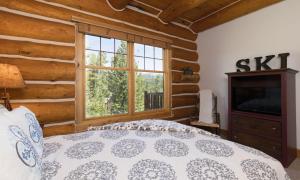 - une chambre avec un lit et une grande fenêtre dans l'établissement Powder Ridge Cabin Rosebud 7, à Big Sky