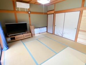 uma sala de estar com uma televisão de ecrã plano ao lado de uma janela em Oyado Nagomi - Vacation STAY 29876v em Takamatsu