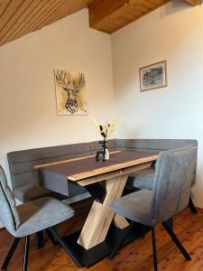 uma mesa de jantar com 2 cadeiras e uma mesa de madeira em Ferienwohnung AlmLust em Hochrindl