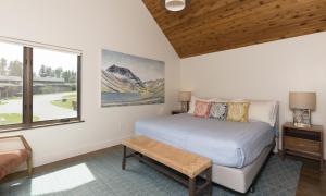 1 dormitorio con cama y ventana en Silvertip Cabin 16 Alpine Bend, en Big Sky