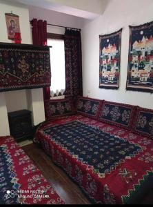 1 dormitorio con 1 cama grande con colcha roja en ΟΡΕΙΝΟ ΟΝΕΙΡΟ en Anilio Metsovo