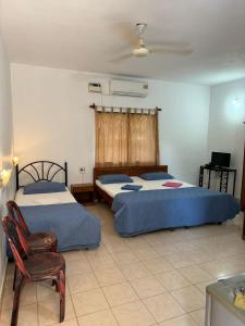 Un dormitorio con 2 camas y una silla. en VILLA SOL BEACH RESORT en Baga