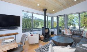 a living room with a couch and a tv and some windows at Lake Cabin 19 Lakewood in Big Sky