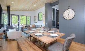 a dining room with a table and a clock on the wall at Lake Cabin 19 Lakewood in Big Sky