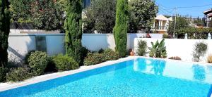 a swimming pool in a garden with trees and a fence at The Central Residence - Kassiopi Corfu Villas in Kassiopi