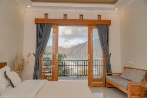 a bedroom with a bed and a balcony with a view at Casa Lago Batur in Kubupenlokan