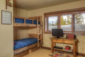 1 dormitorio con 2 literas y TV en MV Leaf Lodge, en Big Sky