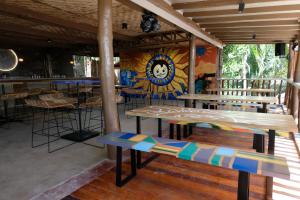 a restaurant with wooden benches and a mural at Mad Monkey Siquijor in Siquijor