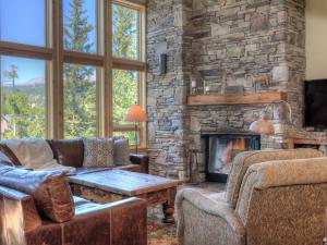 a living room with couches and a stone fireplace at Black Eagle 10 in Big Sky