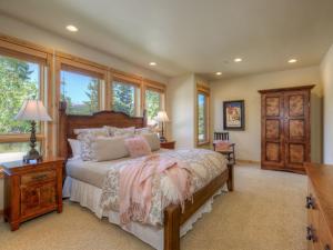 a bedroom with a bed and a desk and windows at Black Eagle 10 in Big Sky