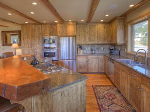 a large kitchen with wooden cabinets andsteel appliances at Black Eagle 32 in Big Sky
