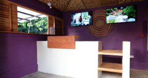 a room with purple walls and a tv on the wall at Mad Monkey Siquijor in Siquijor