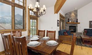 a dining room with a table and a fireplace at Alpenglow 22B in Big Sky
