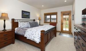 a bedroom with a bed and a dresser and window at Alpenglow 22B in Big Sky