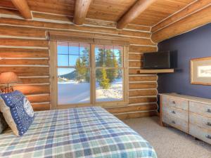Schlafzimmer mit einem Bett und einem Fenster in der Unterkunft Powder Ridge Cabin Moose Ridge 5 in Gallatin Gateway