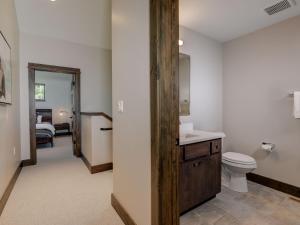 a bathroom with a toilet and a sink and a mirror at Homestead Chalet 6 Claim Jumper in Big Sky