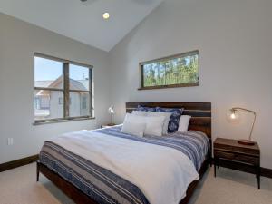 a bedroom with a large bed with two windows at Homestead Chalet 6 Claim Jumper in Big Sky