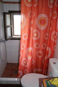 a bathroom with an orange shower curtain and a toilet at Finca Cueva del Viento in Icod de los Vinos +29 photos