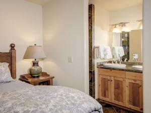 1 dormitorio con 1 cama y baño con lavamanos en Black Eagle 31 en Big Sky