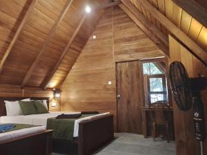 a bedroom with two beds in a wooden cabin at Habarana New Star Homestay in Habarana