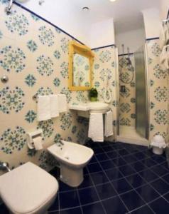 a bathroom with a toilet and a sink and a shower at Hotel Astoria Sorrento in Sorrento